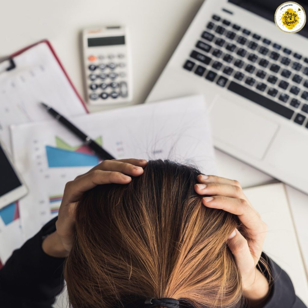 Girl stressed out at her desk with hands on her head